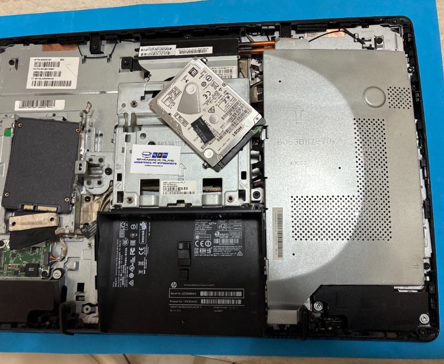 Hard disk HGST 2.5 pollici sollevato dal vano di un All-in-One HP Pavilion 24, prima della sostituzione SSD