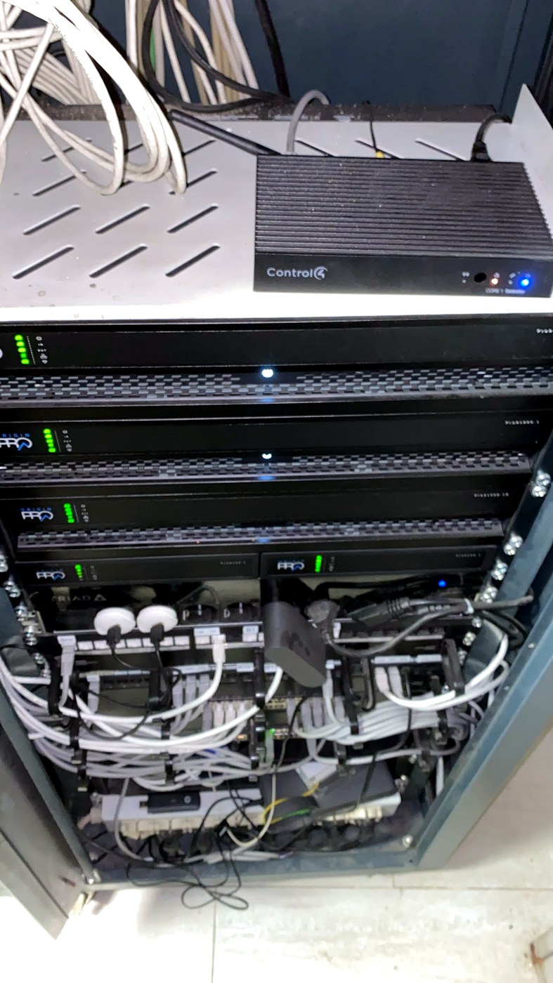 Armadio rack di rete ristorante in Viale Tunisia 16 Milano durante intervento urgente: switch, cavi Ethernet e apparecchiature AV